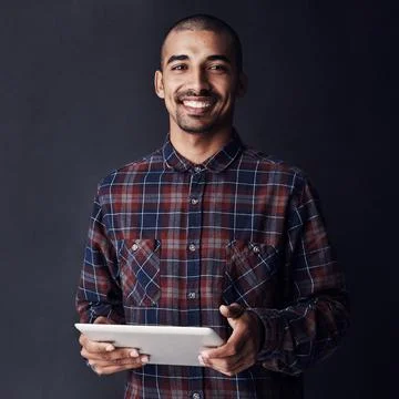 Cool, calm and connected. Studio portrait of a young man using a digital tablet Stock Photos