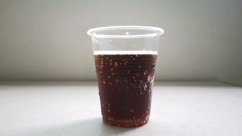 Cool carbonated drinks in a transparent plastic cup on the table Stock Footage 124954682