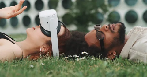 A cool couple lying on the grass using vr goggles Stock Footage 201134319