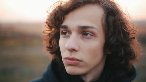 Cool curly young man looking at different sides, close up Vidéo 98749726