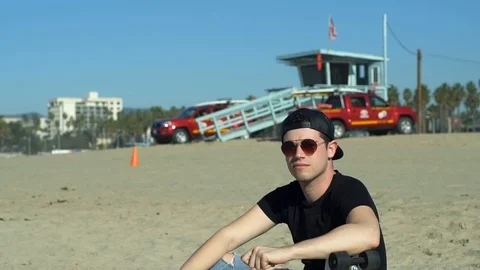 Cool dude sits on the beach Stock Footage 86535616