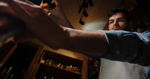Cool experienced bartender mixing an alcohol beverage in a shaker. Authentic Stock-Footage 128316400