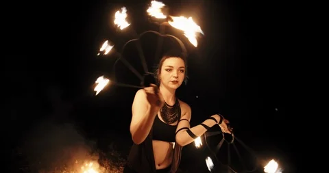 Cool female fire show stuntsman performing, swinging her burning fans - slow Stock-Footage 101006559