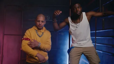 Cool funky rappers team gesturing and dancing together in dark Stock Footage 267819160