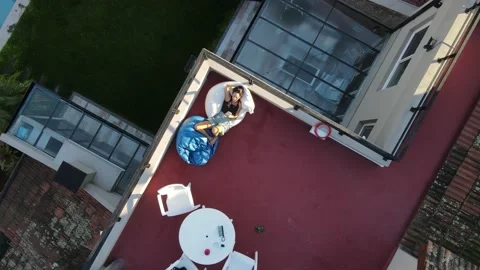 Cool girl lying in rooftop using cellphone at sunset Stock Footage 153779604