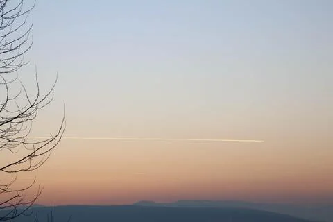 Cool gradient sunset with trace of plane. Stock Photos