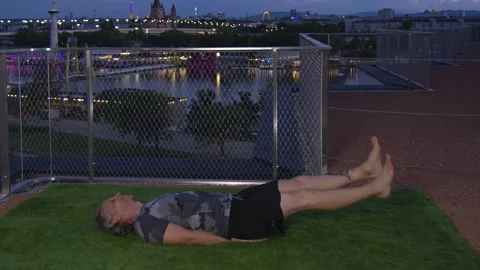 Cool guy is doing Flutter Kicks in the evening on a modern terrace with Stock Footage 251514063