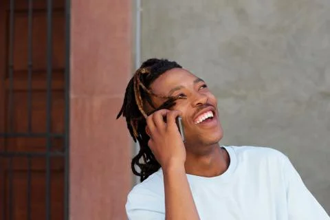 Cool guy with dreadlocks laughing and talking on phone Foto stock