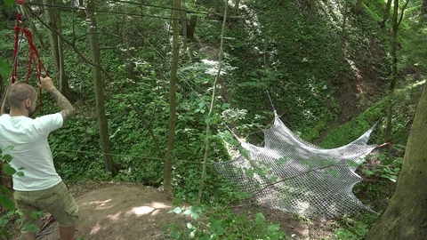 Cool guy jump down of hill and run in forest. 4K Stock Footage 108737322