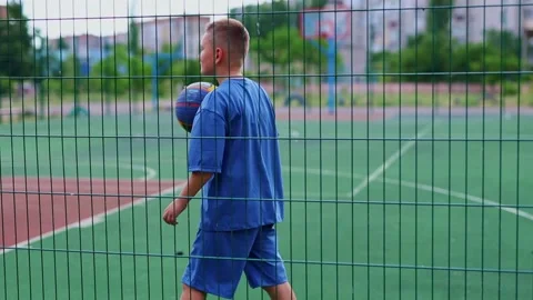 Cool guy with lookinng at the camera and plays with a basketball. Stock Footage 314310843