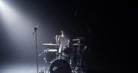 Cool guy playing drums with stick on stage under spotlight Stock Footage 249852315