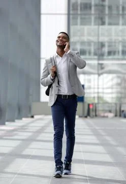 Cool guy walking and talking with cellphone Stock Photos