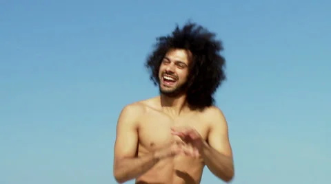 Cool happy man dancing in front of the ocean in summer slow motion closeup Stock Footage 64221118