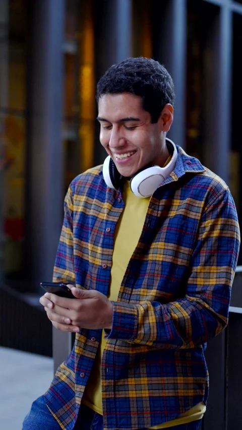 Cool latin student using phone and smiling happily Stock Footage 258325500