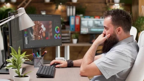 Cool looking bearded videographer or colorist wors on a project Stock Footage 110467461