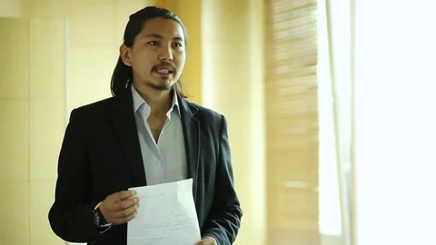 Cool looking businessman practicing a speech in front of the mirror 動画素材 76298971