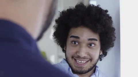 Cool looking middle eastern man with afro chatting in office Stock Footage 67386379