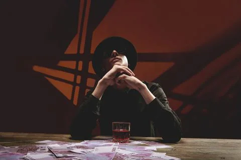 A cool man in dark glasses at a table with money Stock Photos