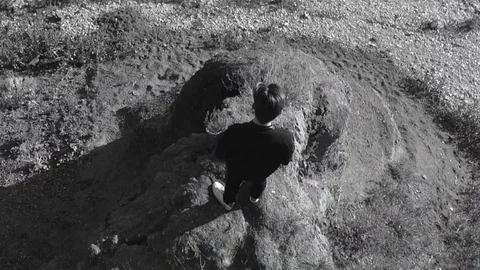 Cool man stands on a hill and looks into the distance black and white image Stock Footage 104699792