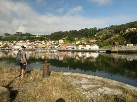 Cool middle aged man contemplating view over a river and a village Stock Photos