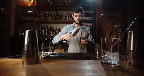 Cool professional caucasian bartender making a cocktail, muddling ice with Stock-Footage 133254126