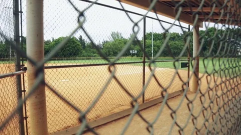 Cool shot of an empty baseball dugout from behind fence Stock Footage 79734473