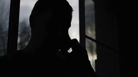 Cool silhouette of a man with a mobile phone attached to his ear Stock Footage