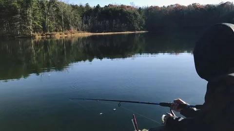 Cool slow motion of a kid fishing on a lake and then taking the fishing rod out Stock Footage 83097635