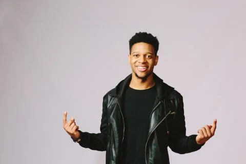 Cool smiling guy with both hands pointing up. Stock Photos