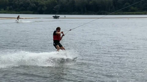 Cool surfer wakeboarding on a sunny summer day. Cheerful man wakeboarding in  Video stock 159595104