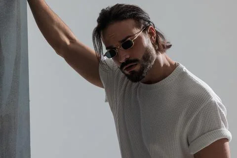 Cool unshaved guy with rectangular sunglasses posing in a fashion way Stock Photos