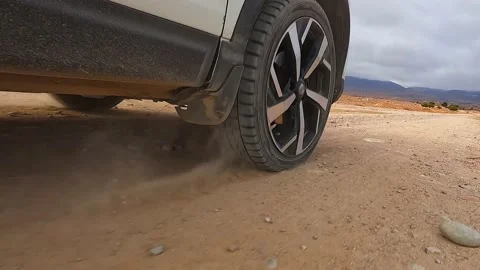 A cool view from below of the wheels of a moving white car. Close-up Stock Footage 230610070