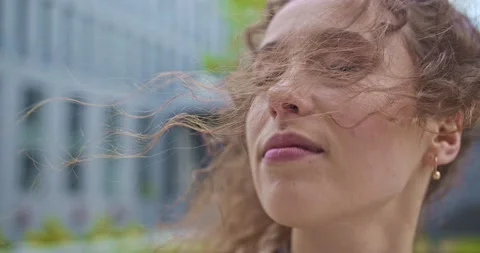 Cool wind blowing through the curly hair of a pretty young woman. Smiling Stock Footage 137157864