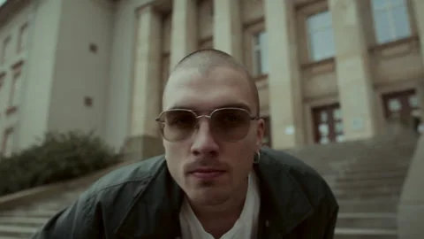 Cool young man in black jacket and sunglasses adjusting his sunglasses Video stock 258274457