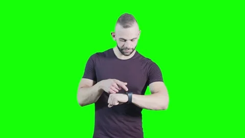 Cool young man using smartwatch against green background Stock Footage 136369730