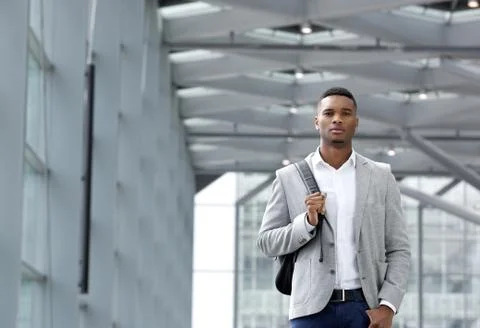 Cool young man walking inside station building with bag Stock Photos