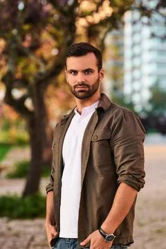 Cool young Middle Eastern guy looking at camera in urban park Stock Photos