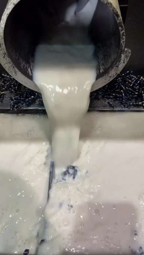 Coolant fluid  flows into the metalworking machine's chip tray, lubricating a Stock Footage 325649057