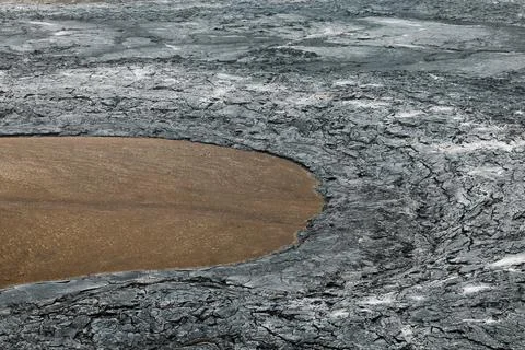 Cooled lava rocks surrounding a patch of red soil near Geldingadalir volcano in Stock Photos