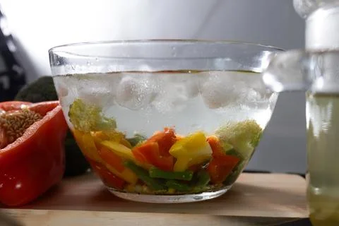 Cooling blanched vegetables in an ice bath on a kitchen counter Fotos Stock
