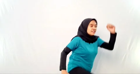 Cooling down exercise jumping woman wearing a hijab in blue 스톡 동영상 292330671