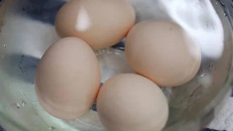Cooling hard boiled eggs in ice water Stock Footage 131412099