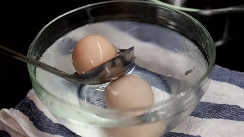 Cooling hard boiled eggs in ice water Stock Footage 131412107