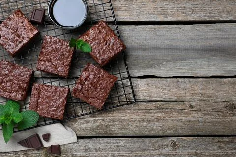 Cooling rack with delicious chocolate brownies and fresh mint on wooden table Stock Photos