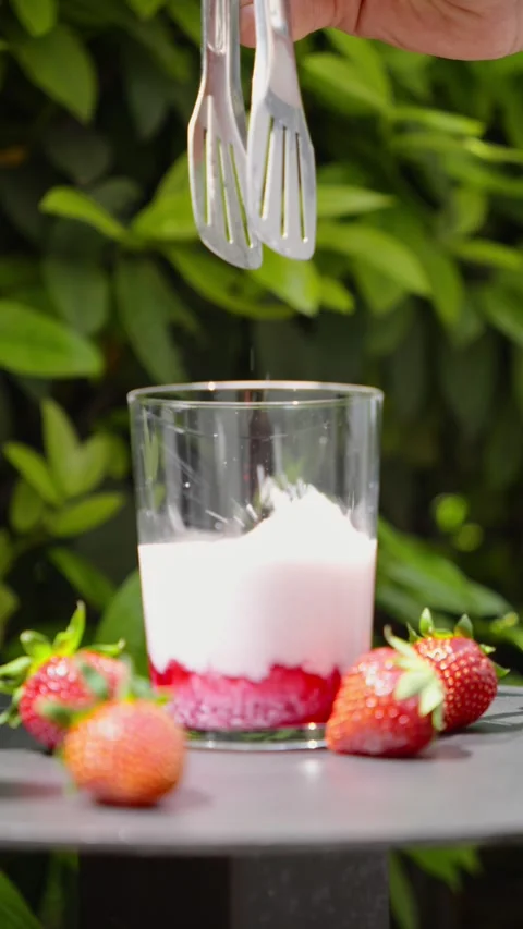 Cooling Strawberry Milk with Ice Cube, Slow Motion Stock Footage 338447840