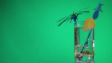 Cooling summer drink with lemon and kiwi rotate on a green background. Stock Footage 131947516