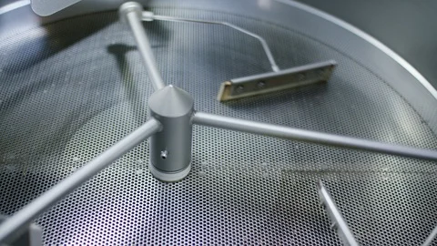 Cooling tray of coffee roastery spinning before a batch of roasted coffee beans Stock Footage 101339097