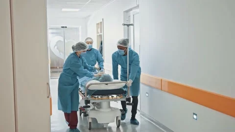 Cooperating multi-race team of paramedic doctors moving seriously injured male Stock Footage 143680658