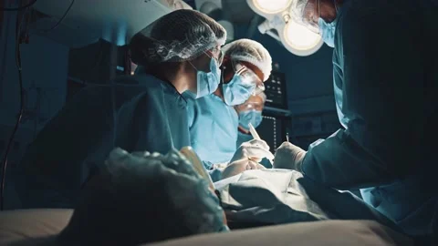 Cooperating team of multi-ethnic surgeous perform organ transplant operation Stock Footage 143679217
