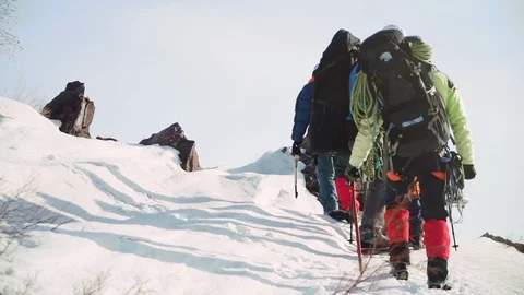 Coordinated a group of climbers climb the steep snow slope of the mountain, they Stock Footage 105876490